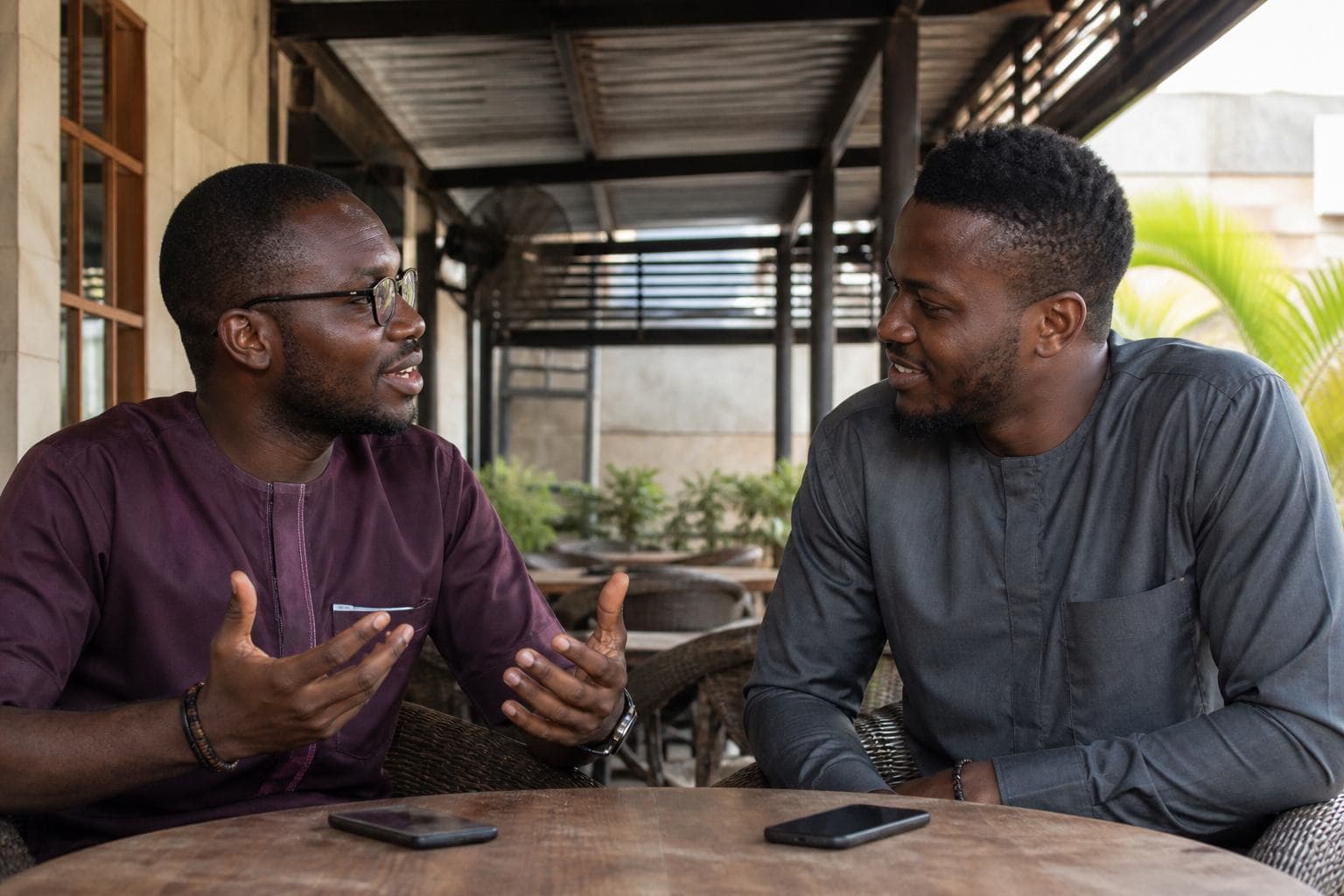 Two friends at a Nigerian cafe after a completed moment together — a snapshot of everyday participation, not a jackpot scene